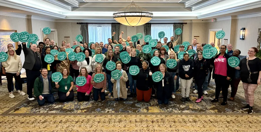 group photo people holding up green foam fists